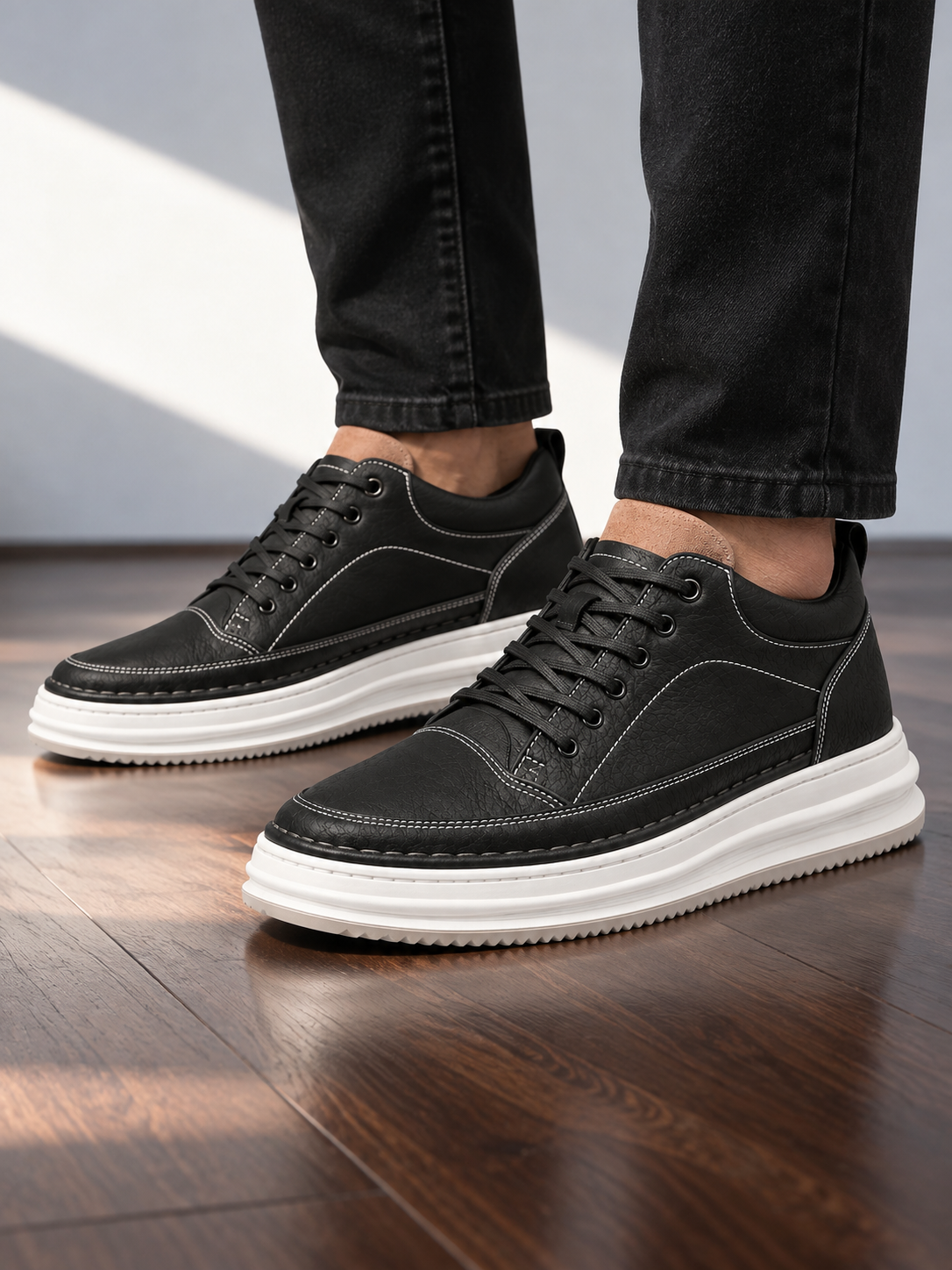 Men's black leather-look platform trainers with white sole, side view