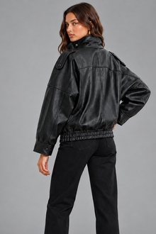 Women's oversized black faux leather bomber jacket, back view