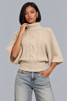 Women's beige cable knit turtleneck jumper with cape sleeves, front view