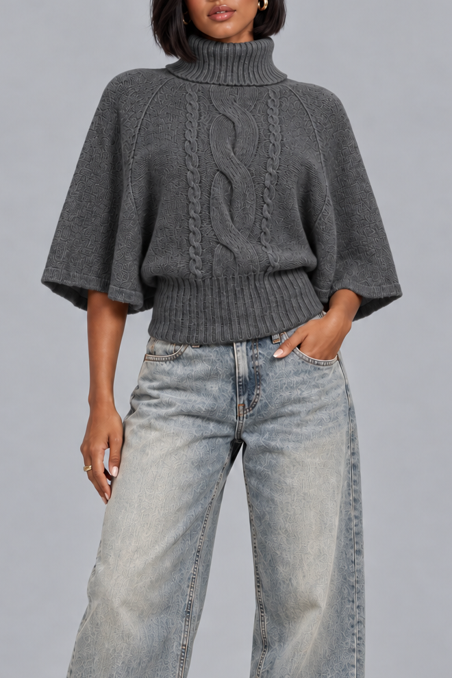 Women's dark grey cable knit turtleneck jumper with cape sleeves, front view