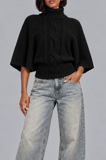 Women's black cable knit turtleneck jumper with cape sleeves, front view