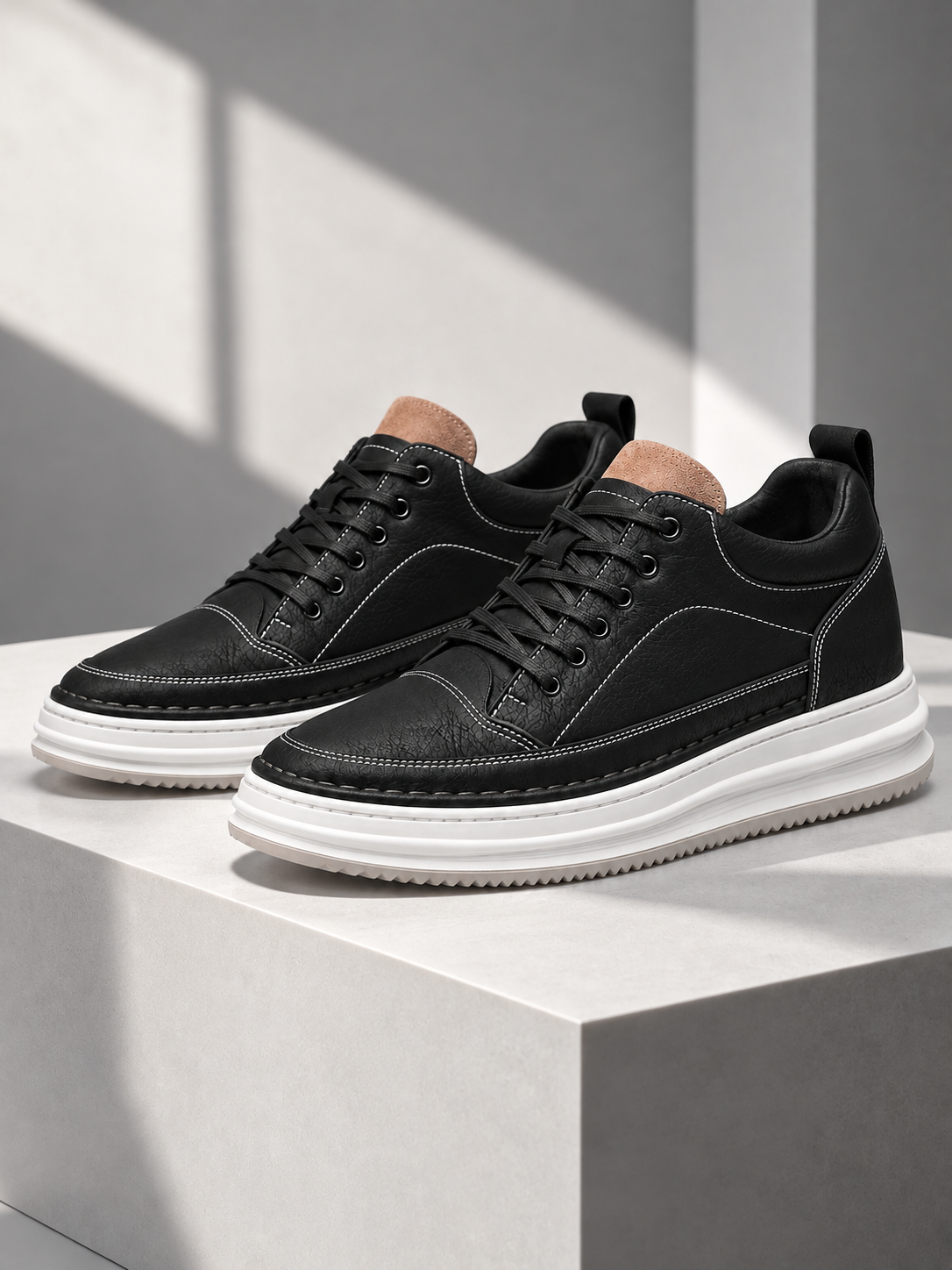 Men's black platform trainers on a white pedestal