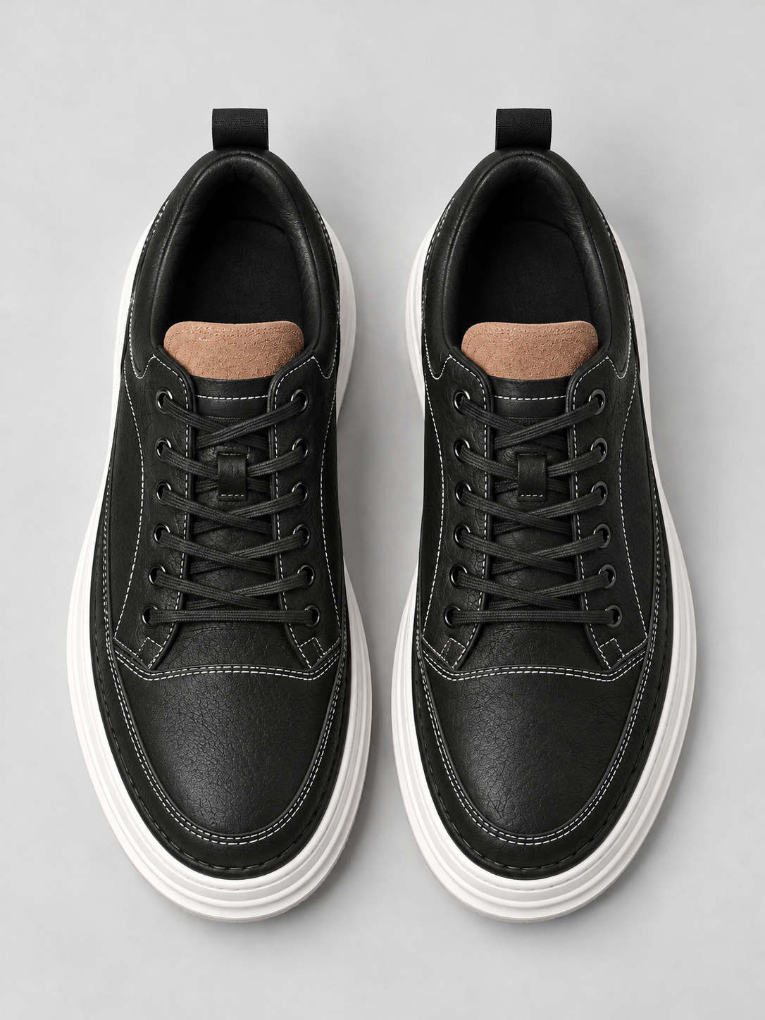 Pair of men's black leather-look platform trainers, top view