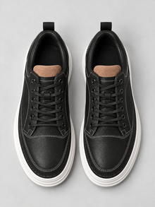 Pair of men's black leather-look platform trainers, top view