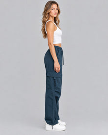 Blue cotton cargo trousers with white crop top, side view showing cargo pocket