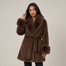 Women's brown faux fur belted coat styled studio pose