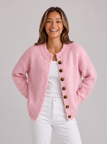 Woman wearing pink fluffy knit button-front round neck cardigan with white jeans