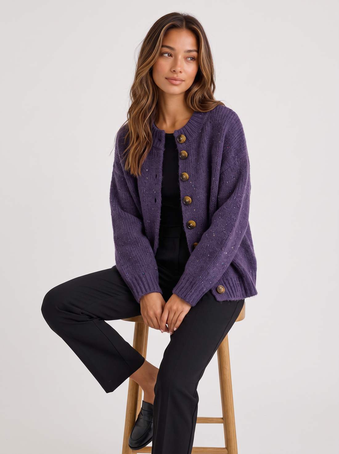 Woman wearing dark purple lavender fluffy knit button-front round neck cardigan seated