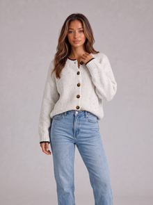 Woman wearing white fluffy knit button-front round neck cardigan with light blue jeans
