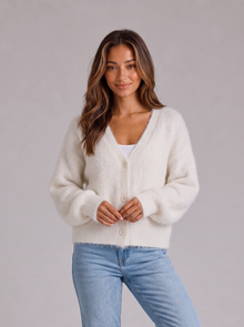 Woman wearing white fluffy knit button-front V-neck cardigan with light blue jeans