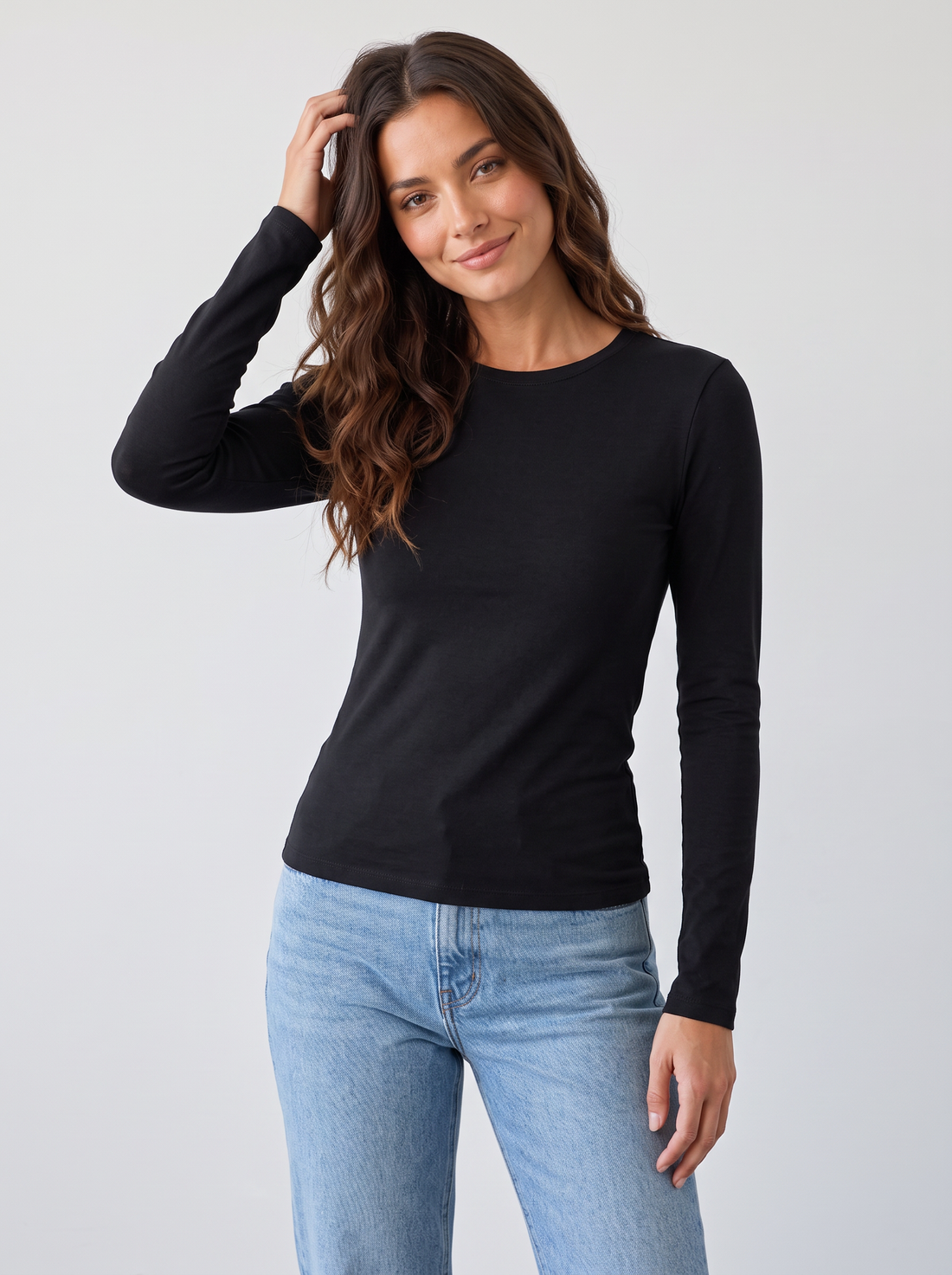 Woman wearing black slim fit round neck long sleeve top with light blue jeans