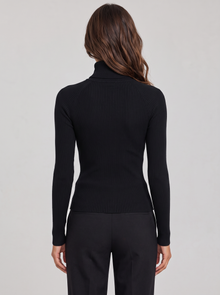 Woman wearing black ribbed roll neck long sleeve top, back view