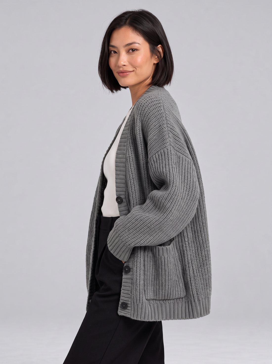 Woman wearing oversized chunky knit button cardigan in grey