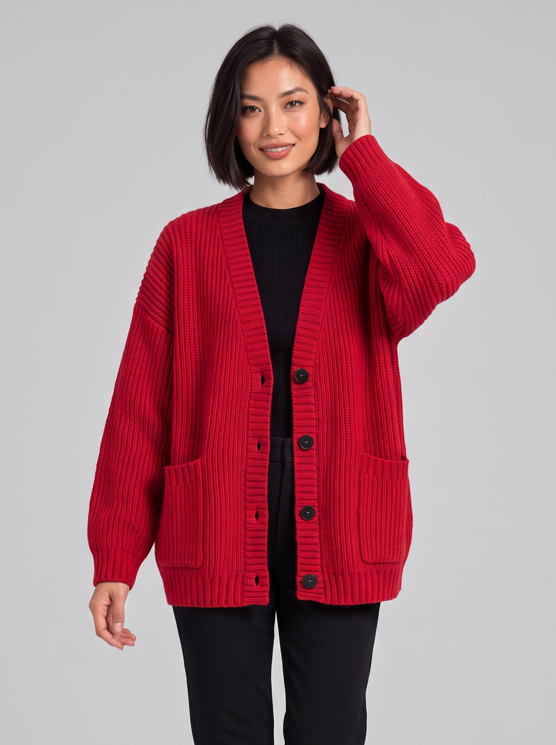 Woman wearing oversized chunky knit button cardigan in red