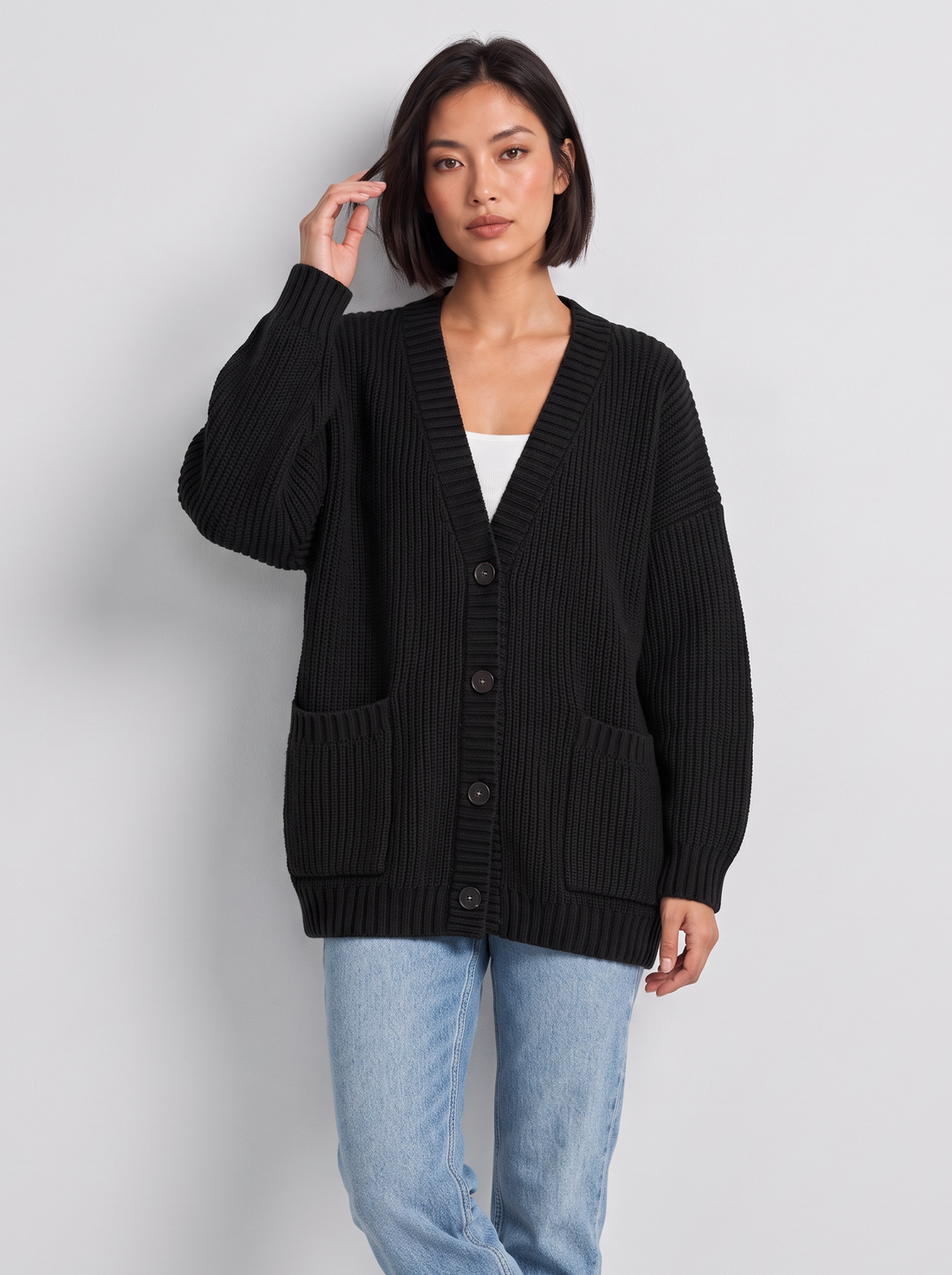 Woman wearing oversized chunky knit button cardigan in black