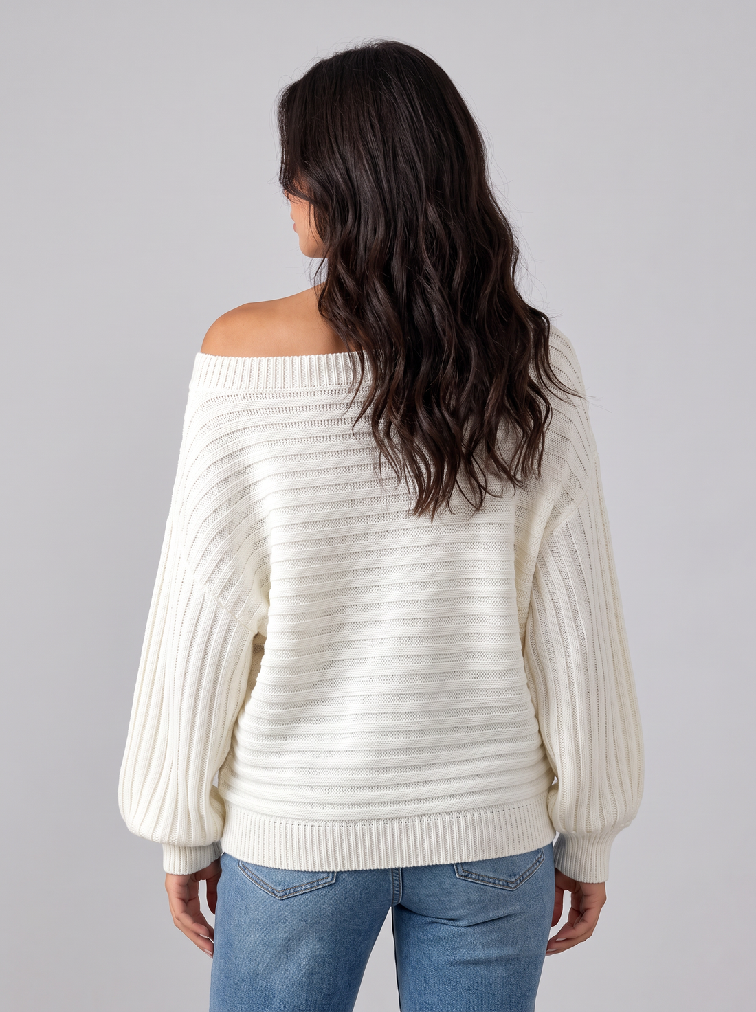 Woman wearing white chunky ribbed off-shoulder batwing jumper, front view