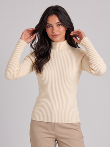 Woman wearing apricot slim fit ribbed mock neck jumper