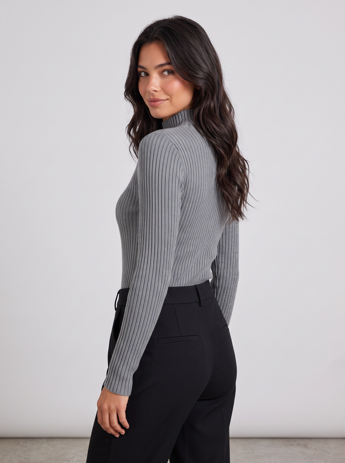 Woman wearing grey slim fit ribbed mock neck jumper