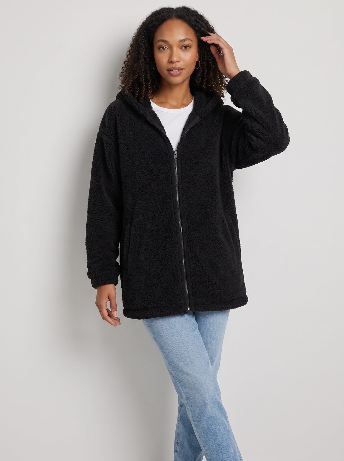 Woman wearing black hooded teddy fleece cardigan with pockets