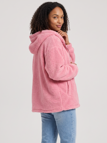 Woman wearing pink hooded teddy fleece cardigan with pockets