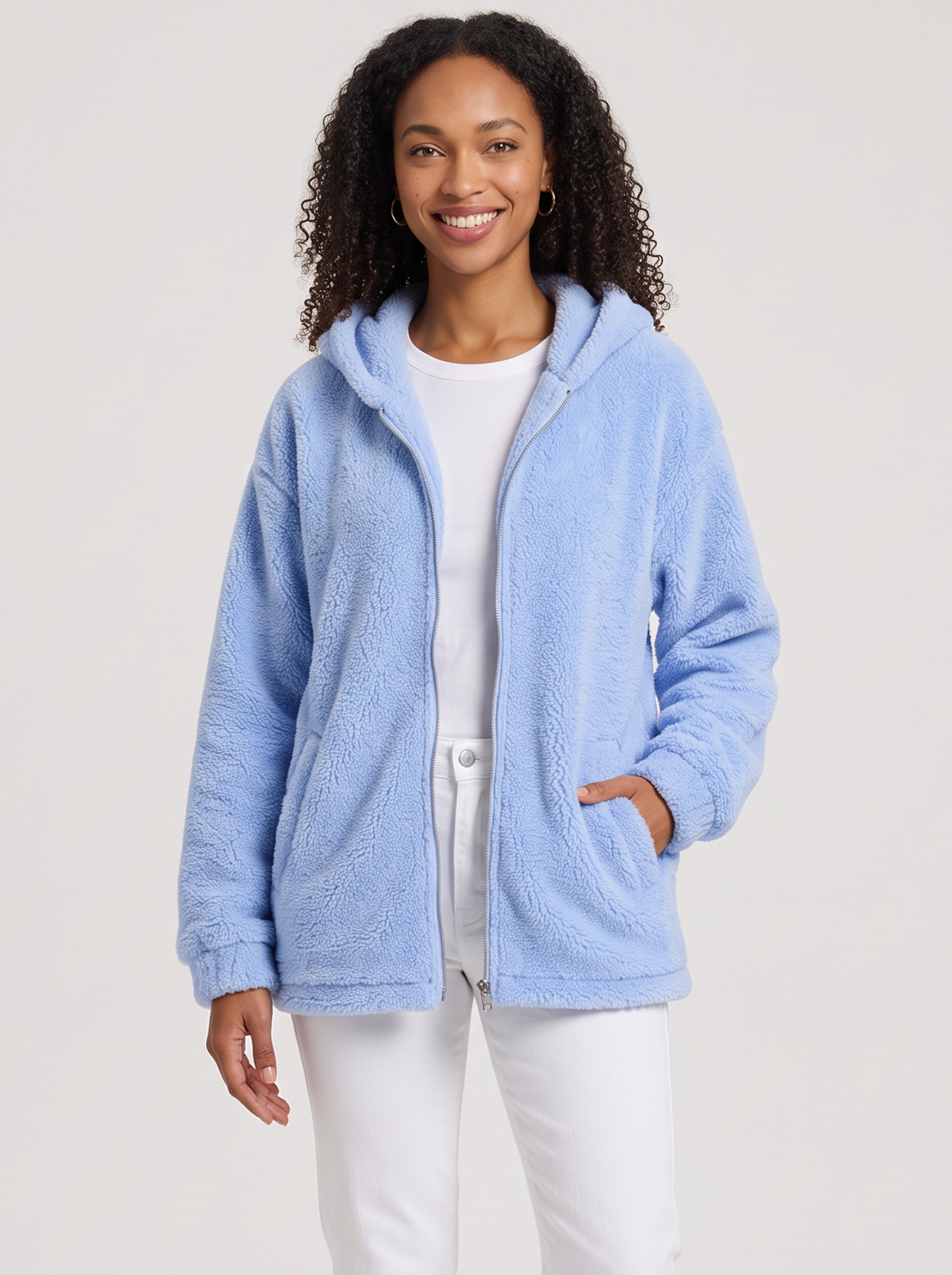 Woman wearing light blue hooded teddy fleece cardigan with pockets