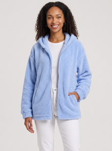 Woman wearing light blue hooded teddy fleece cardigan with pockets