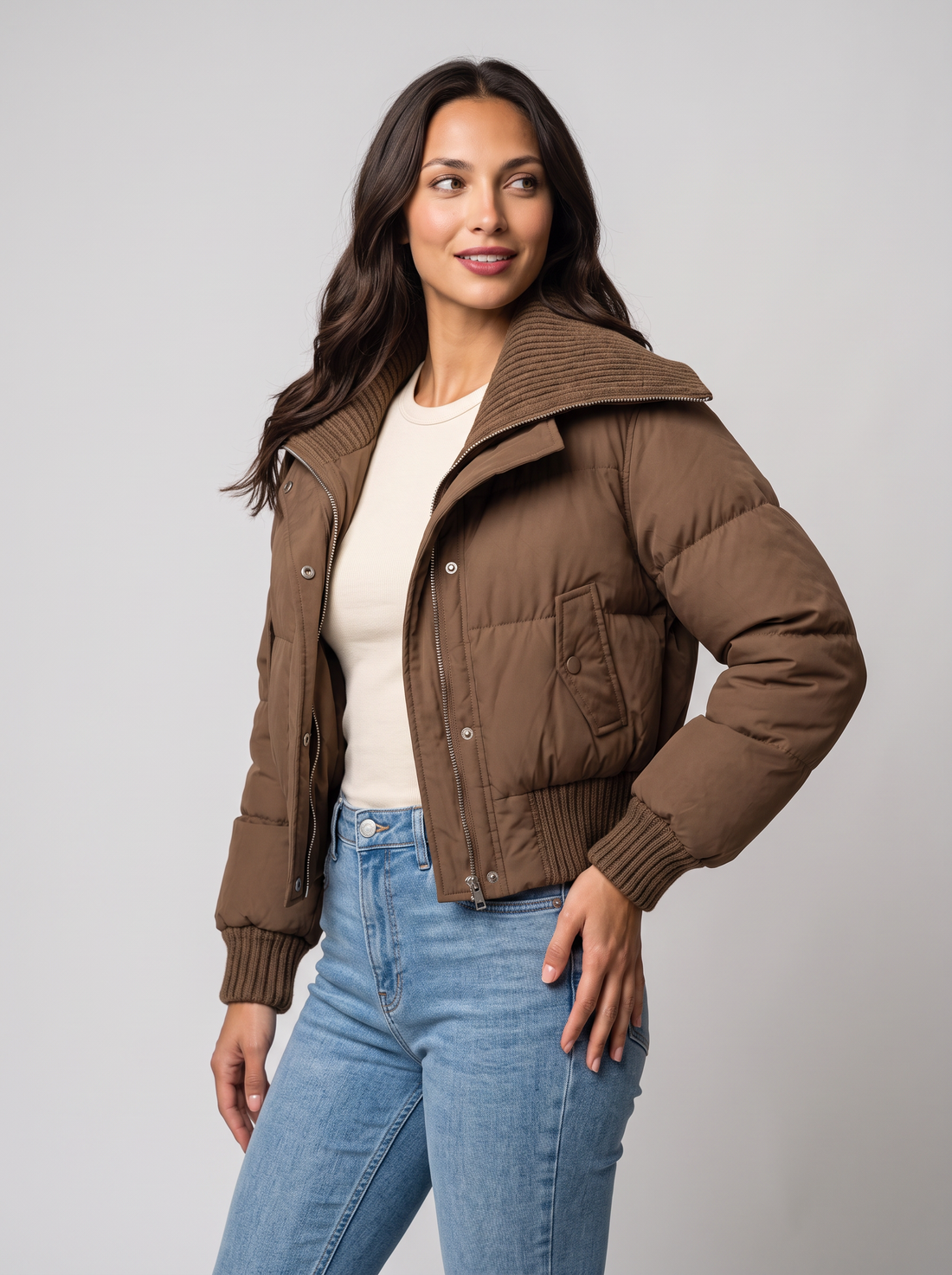 Brown cropped puffer jacket with ribbed knit collar, side view with jeans