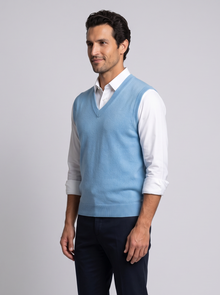 Blue merino wool sweater vest for men, side view with navy trousers