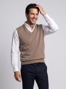 Smiling man in camel merino wool sweater vest over white shirt