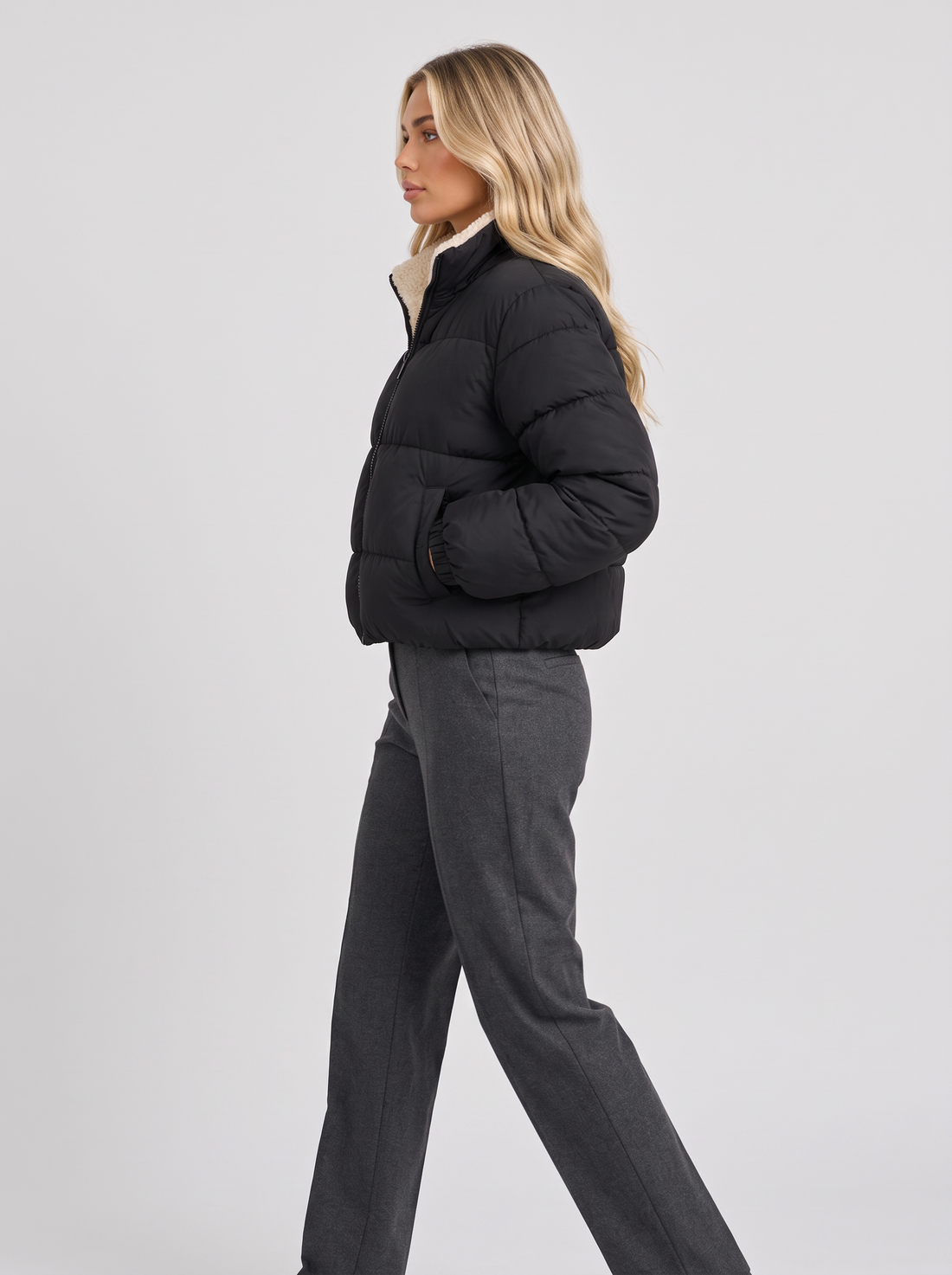 Women's black cropped quilted jacket, side view walking