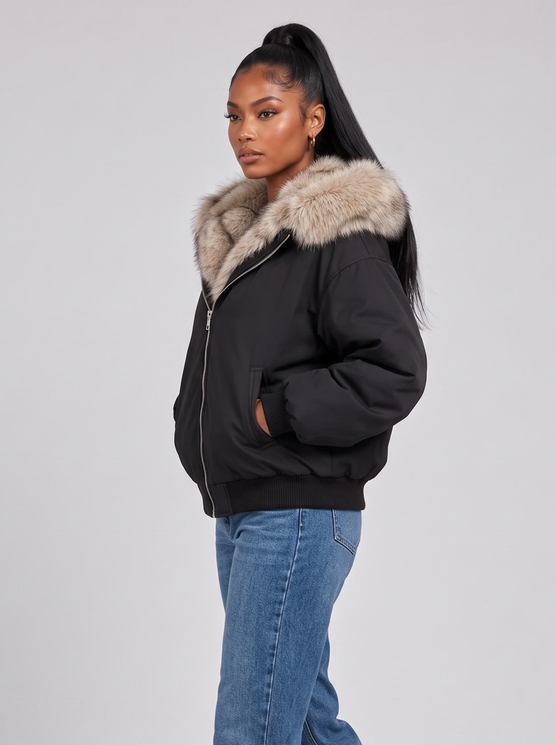 Women's black puffer jacket with faux fur hood, side view walking
