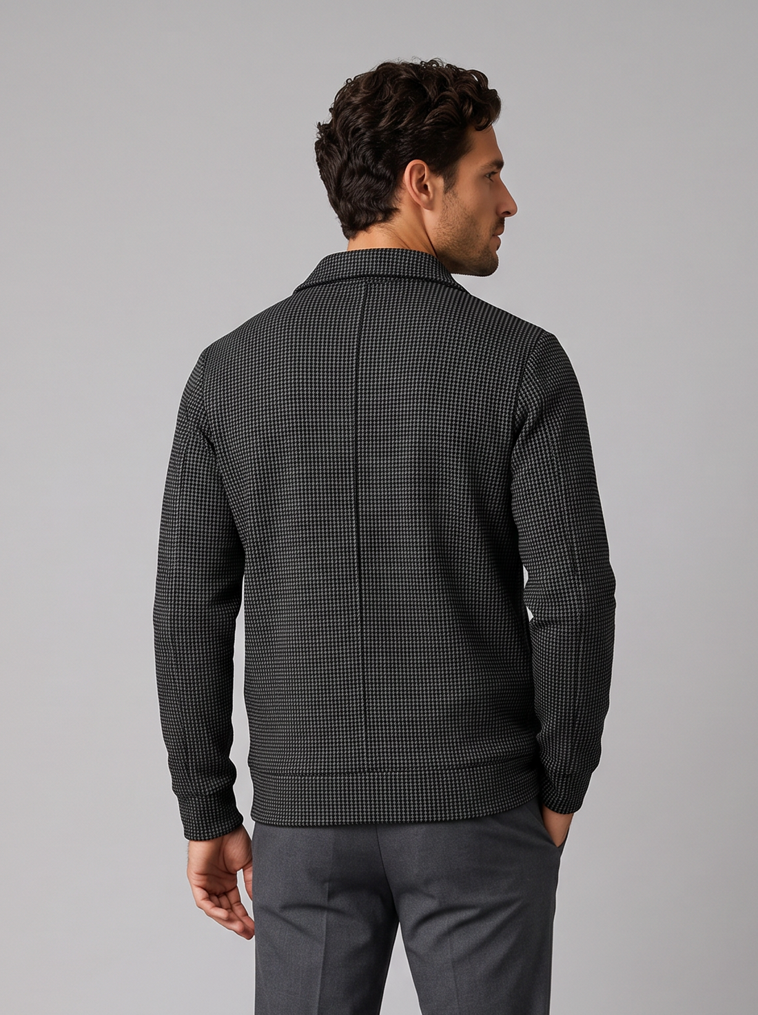 Man wearing black textured collared zip-up jacket, front view