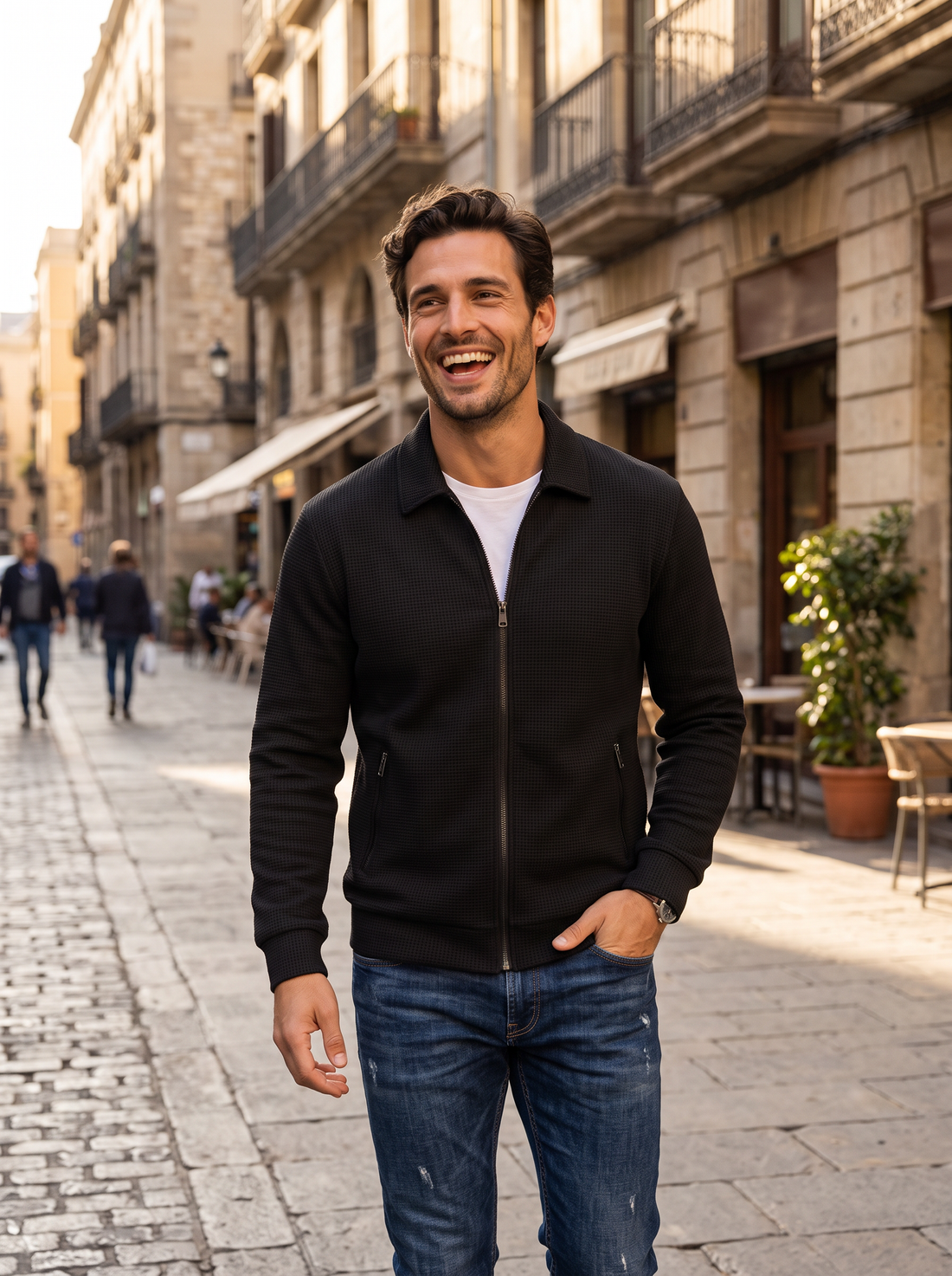 Man in black textured jacket walking on a sunny city street