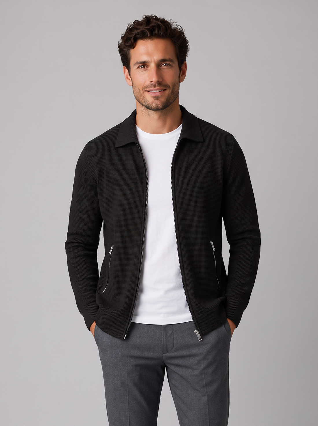 Man wearing black textured collared zip-up jacket, front view
