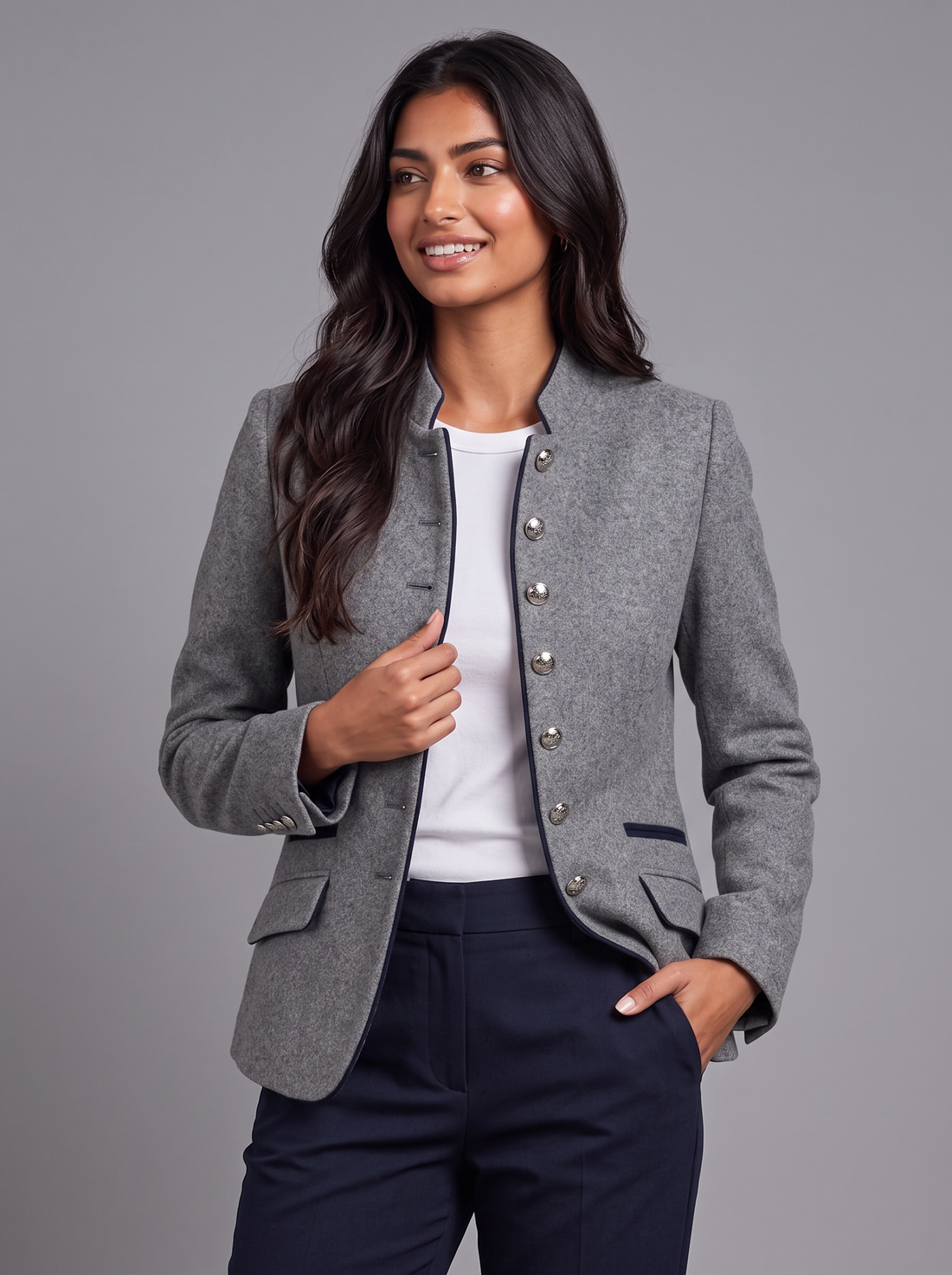 Women's grey wool-blend blazer with stand collar and navy piping, worn with hand in pocket