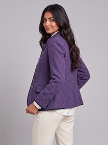 Women's purple wool-blend blazer with stand collar and navy piping, glancing over shoulder