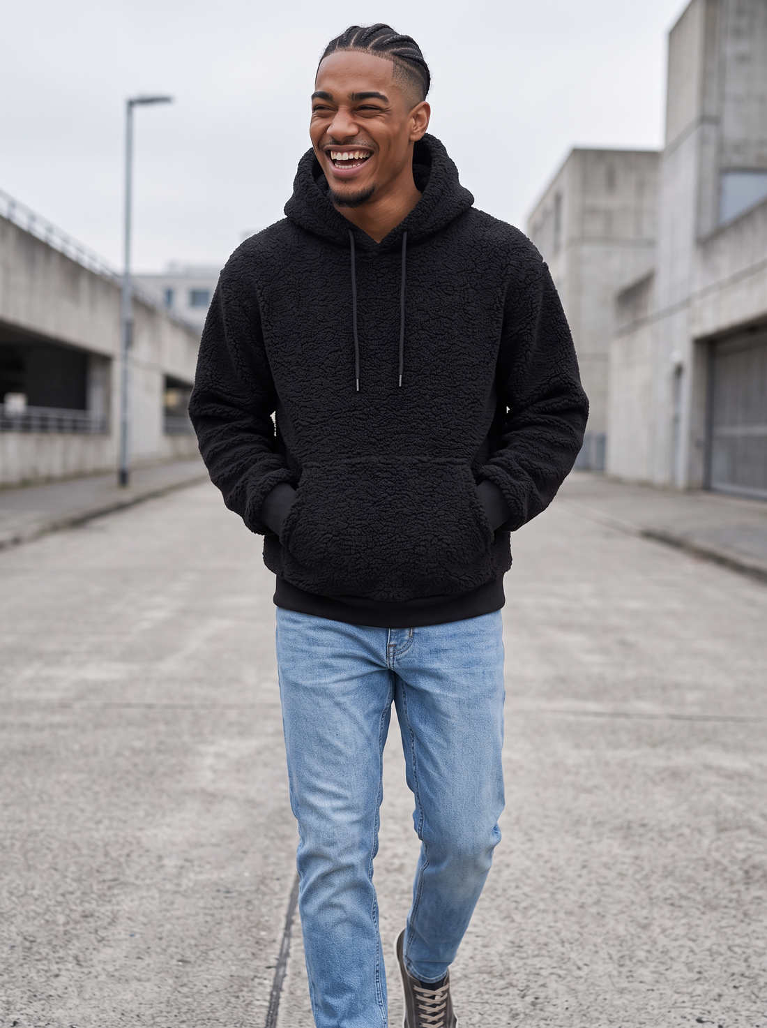 Man walking in a black fleece teddy pullover hoodie on a city street