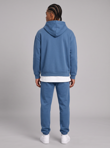 Men's blue oversized hoodie and tapered joggers tracksuit set, back view