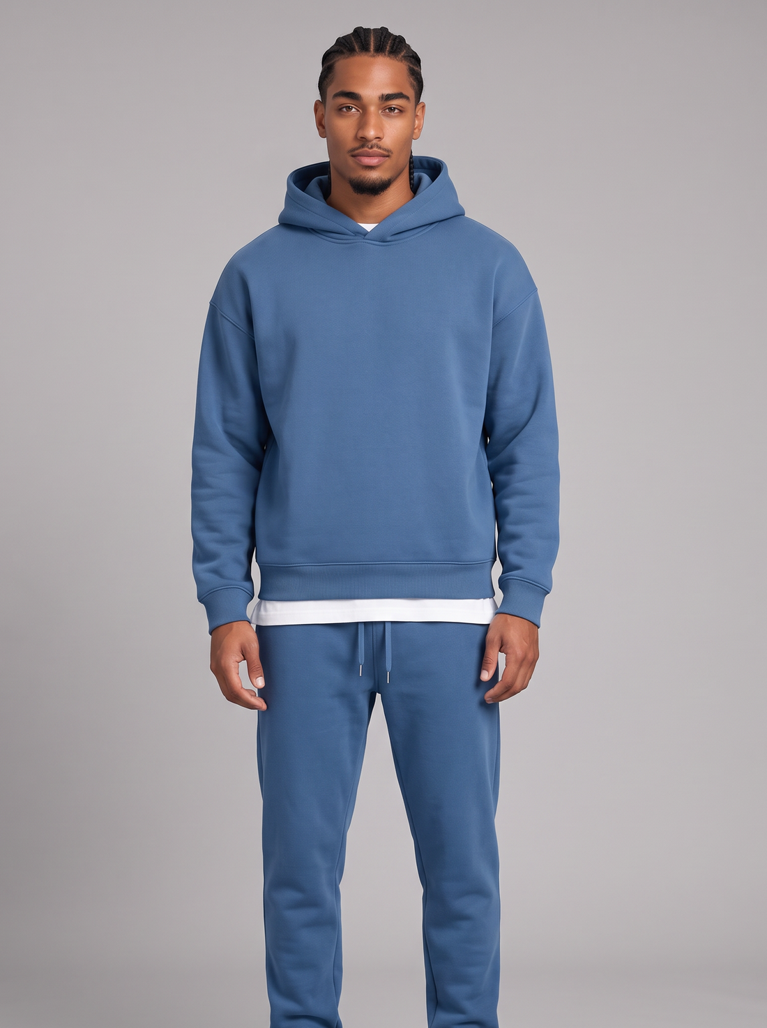 Men's blue oversized hoodie and tapered joggers tracksuit set with white tee, front view