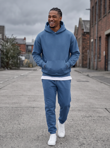 Man walking in a blue hoodie and joggers tracksuit set on a city street
