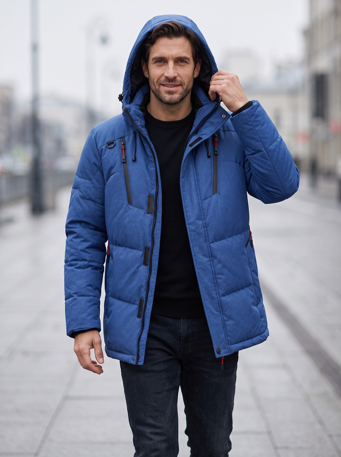 Man walking in a blue insulated hooded parka on a city street