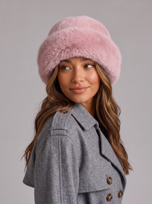 Woman wearing a pink faux fur hat with a rolled brim