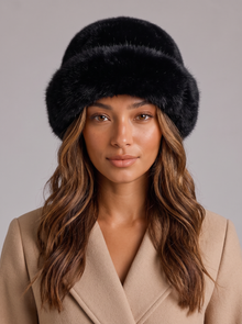 Woman wearing a black faux fur hat with a rolled brim
