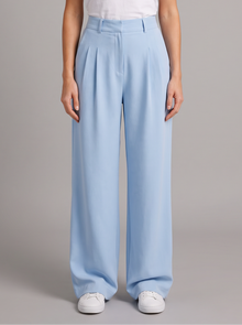 Woman wearing sky blue high-waist pleated wide leg trousers, front view