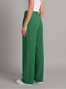 Woman wearing green pleated wide leg trousers