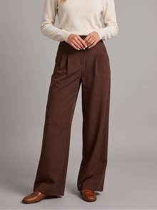 Woman wearing brown pleated wide leg trousers