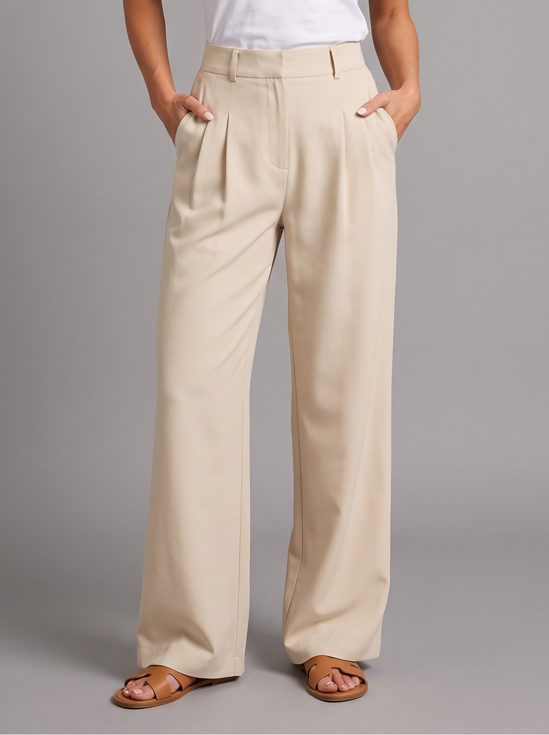 Woman wearing apricot pleated wide leg trousers