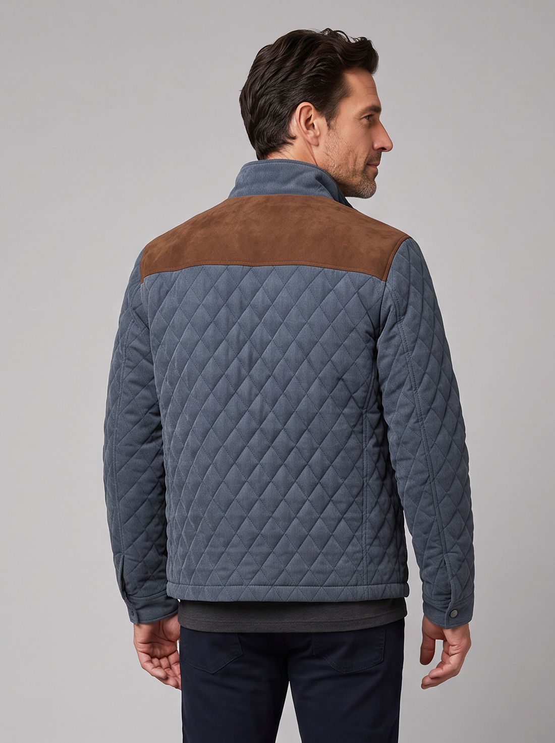 Man wearing a blue-grey diamond quilted jacket with brown suede yoke, front view