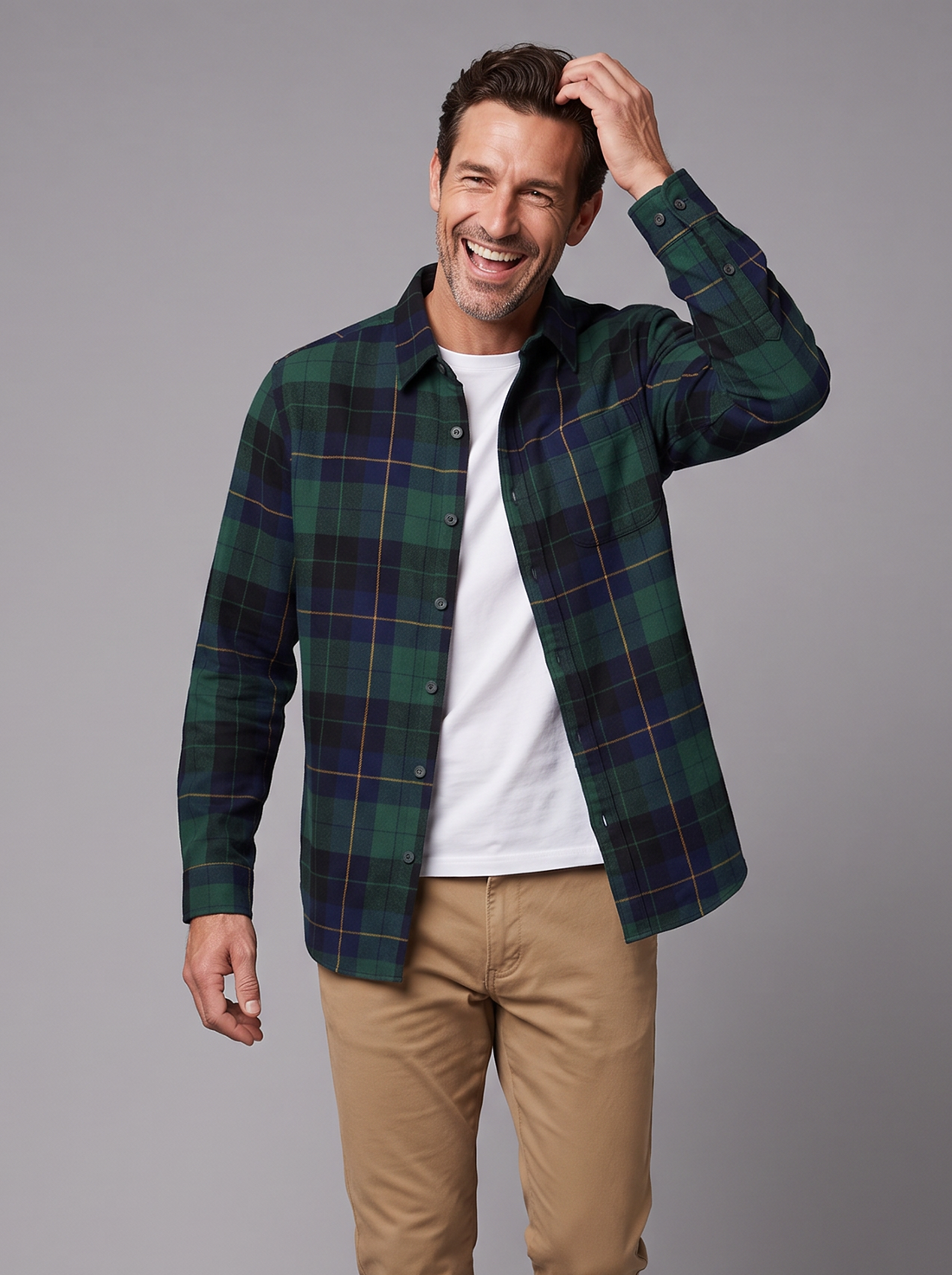 Man wearing a Blackwatch plaid flannel overshirt with a white tee and chinos