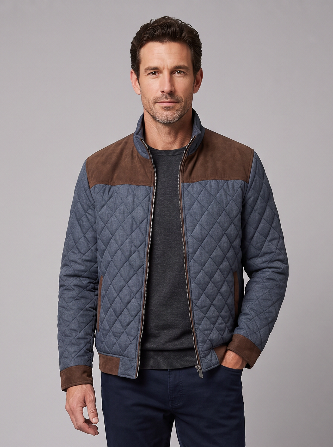 Man wearing a blue-grey diamond quilted jacket with brown suede yoke, front view